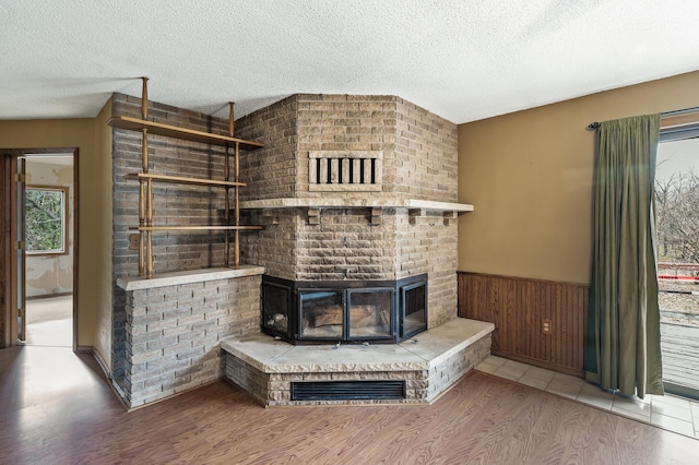 living room featuring a textured ceiling, wood-type flooring, and a fireplace