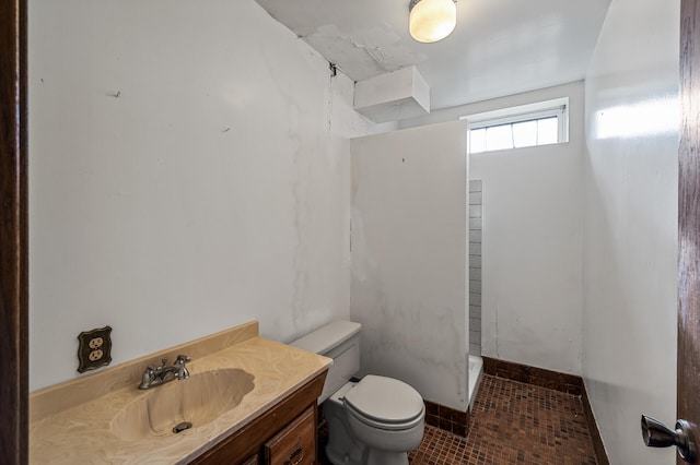 bathroom with a shower, vanity, and toilet