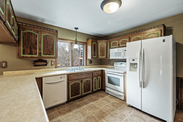 kitchen featuring pendant lighting, dark brown cabinetry, white appliances, and sink