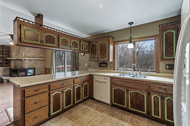 kitchen with white dishwasher, sink, ceiling fan, decorative light fixtures, and kitchen peninsula