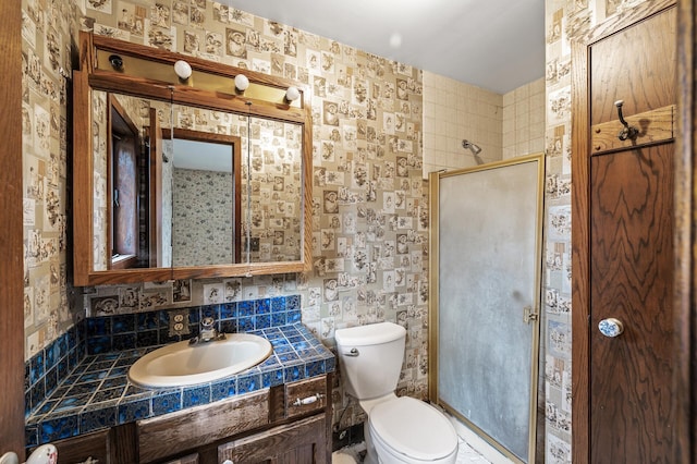 bathroom with decorative backsplash, toilet, a shower with door, and vanity