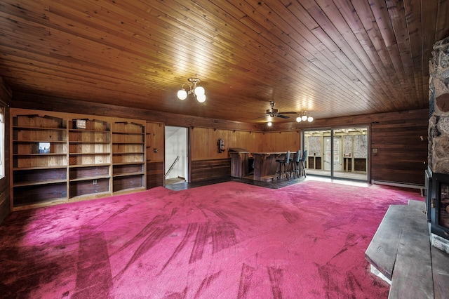 interior space featuring carpet floors, wooden ceiling, and wood walls