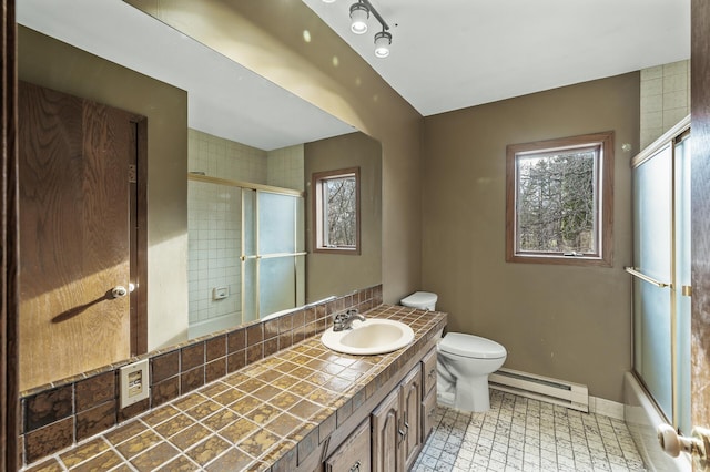 full bathroom with baseboard heating, vanity, enclosed tub / shower combo, and toilet