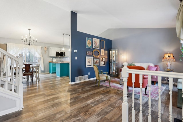 interior space featuring lofted ceiling, dark hardwood / wood-style flooring, and an inviting chandelier