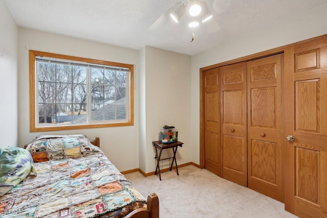 carpeted bedroom featuring a closet and ceiling fan