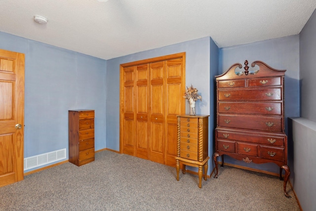 bedroom with a closet, carpet, and a textured ceiling