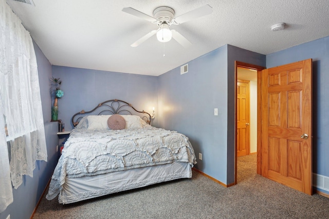 carpeted bedroom featuring ceiling fan and a textured ceiling