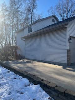 view of snow covered exterior featuring a garage