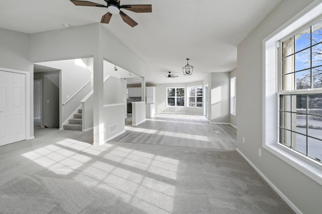 unfurnished living room featuring ceiling fan and light colored carpet