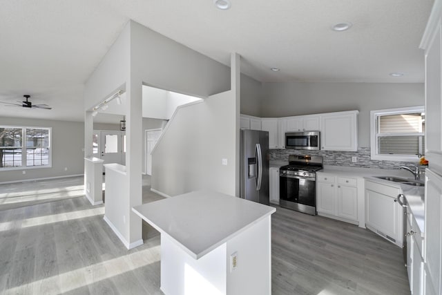 kitchen featuring ceiling fan, appliances with stainless steel finishes, white cabinetry, and a center island