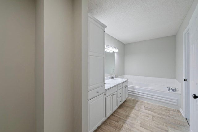 bathroom with vanity, a bathtub, a textured ceiling, and hardwood / wood-style flooring