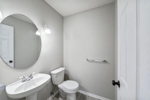 bathroom featuring sink, hardwood / wood-style floors, and toilet