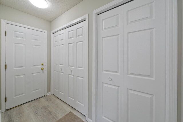 interior space featuring a textured ceiling and light hardwood / wood-style flooring