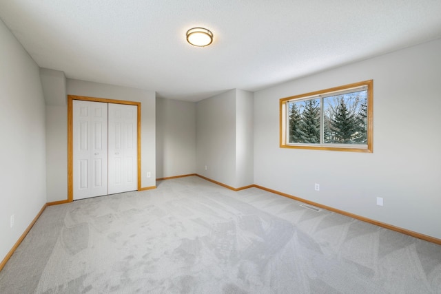 unfurnished bedroom featuring a closet and light carpet