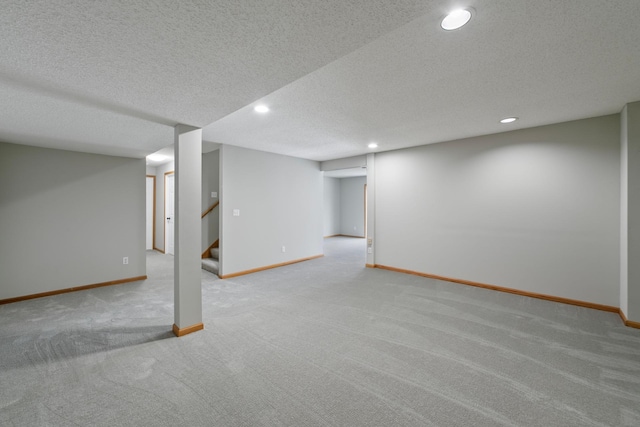 basement featuring a textured ceiling and light colored carpet