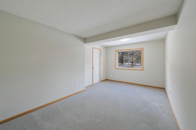 carpeted spare room featuring a textured ceiling