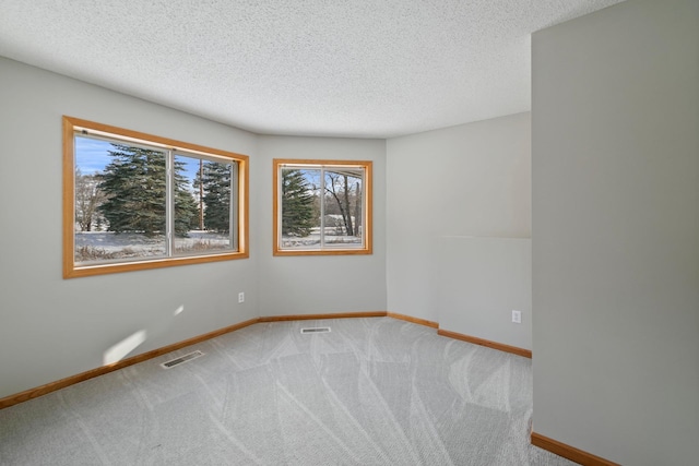 carpeted spare room with a textured ceiling