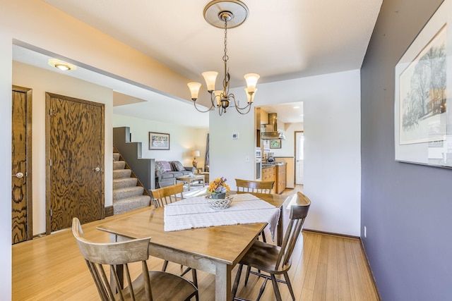 dining room with light hardwood / wood-style floors and a chandelier