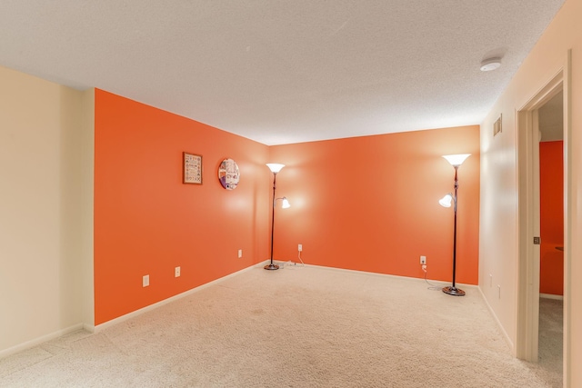 carpeted spare room featuring a textured ceiling