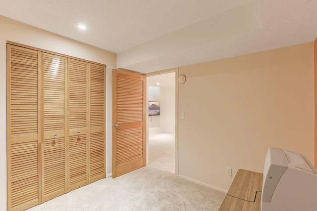 carpeted bedroom featuring a closet and a textured ceiling