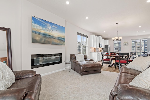 living room with light carpet, a healthy amount of sunlight, and a notable chandelier