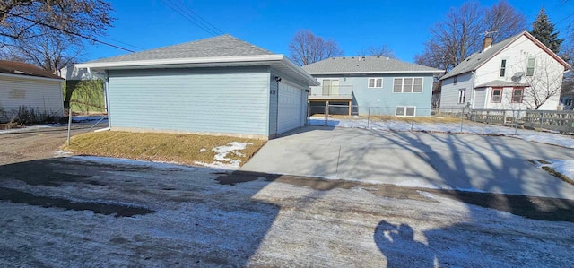 rear view of property with an outbuilding and a garage