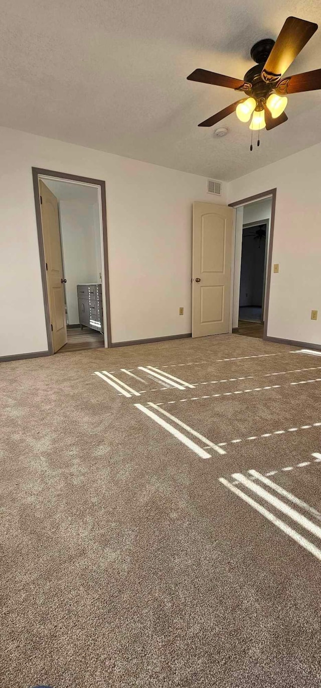 unfurnished room with ceiling fan, carpet floors, and a textured ceiling