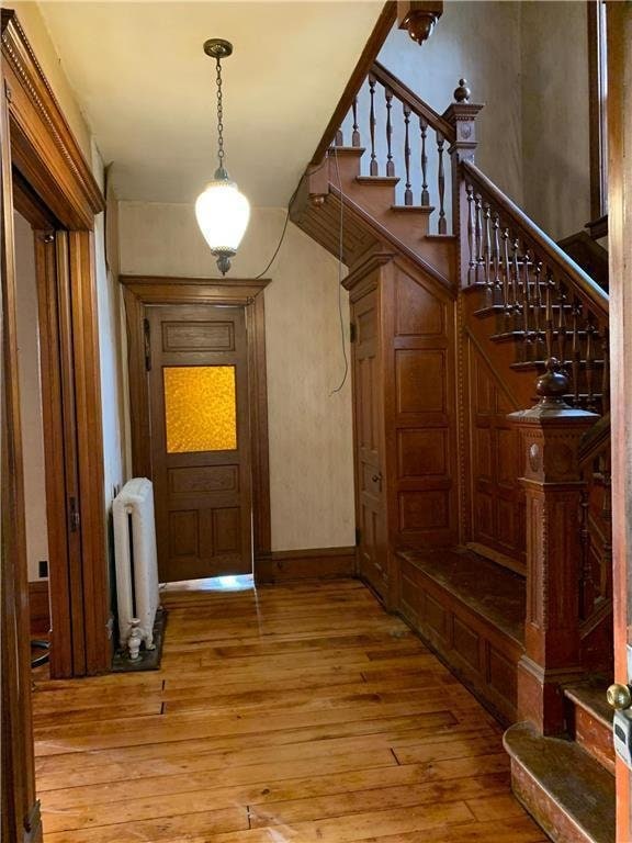 hall with light hardwood / wood-style floors and radiator heating unit