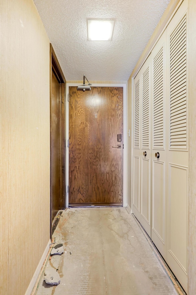 hall with a textured ceiling