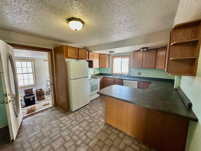 kitchen featuring kitchen peninsula, white appliances, and sink