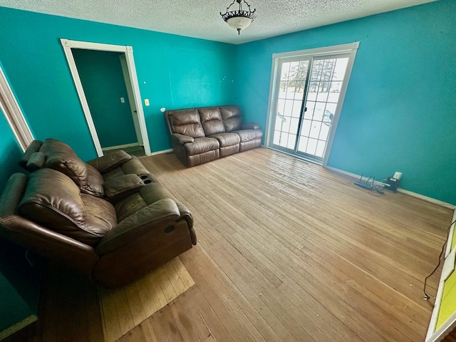 living room with a textured ceiling and light wood-type flooring