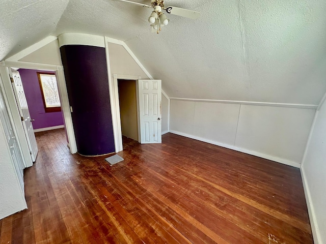 bonus room with dark hardwood / wood-style floors, ceiling fan, a textured ceiling, and vaulted ceiling