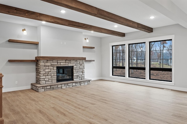 unfurnished living room with a stone fireplace and light hardwood / wood-style flooring