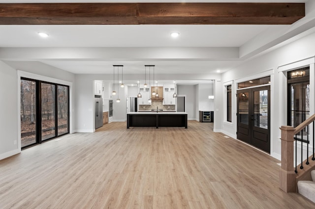 unfurnished living room featuring plenty of natural light and light wood-type flooring