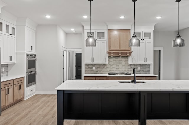 kitchen featuring white cabinetry, light stone countertops, and a spacious island