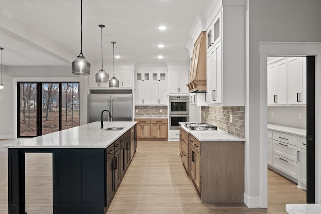 kitchen with white cabinetry, a large island, pendant lighting, and appliances with stainless steel finishes