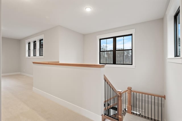 hall with light colored carpet