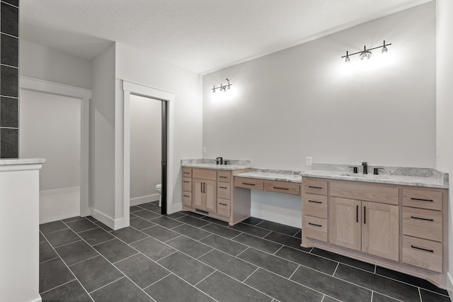 bathroom with vanity, a textured ceiling, toilet, and tile patterned flooring