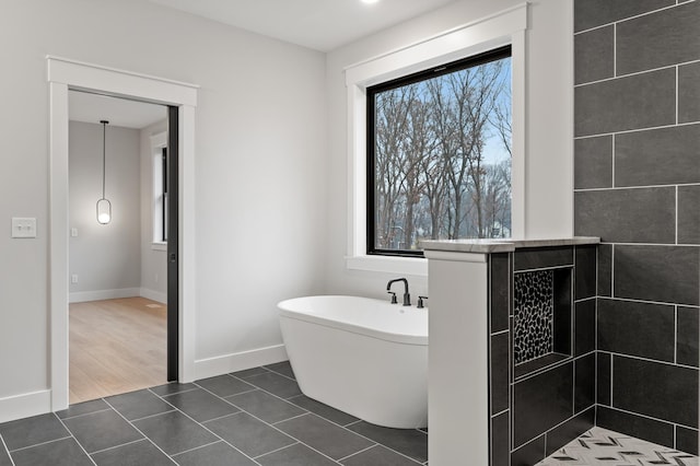 bathroom with tile patterned floors and a tub