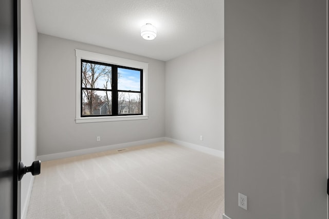 carpeted spare room featuring a textured ceiling