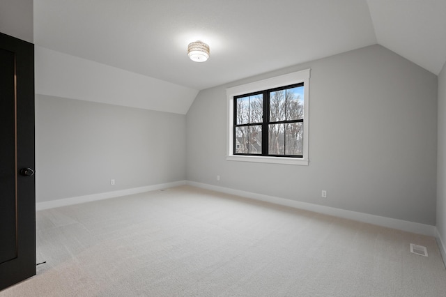 bonus room with light colored carpet and lofted ceiling