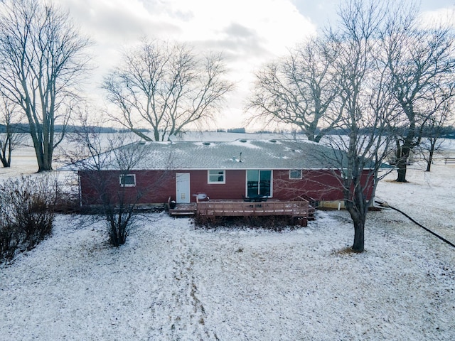 snow covered rear of property with a wooden deck