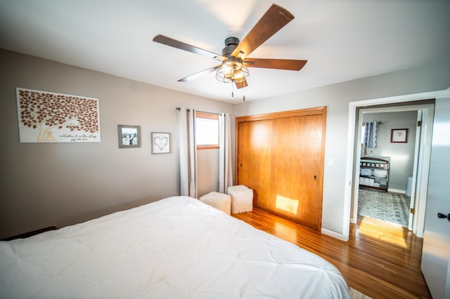 bedroom with ceiling fan, a closet, and hardwood / wood-style floors