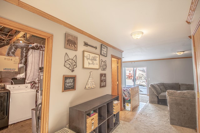 interior space with light colored carpet, ornamental molding, and washer and clothes dryer