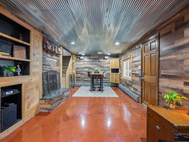 living room featuring a baseboard radiator, built in features, concrete flooring, wooden walls, and wood ceiling