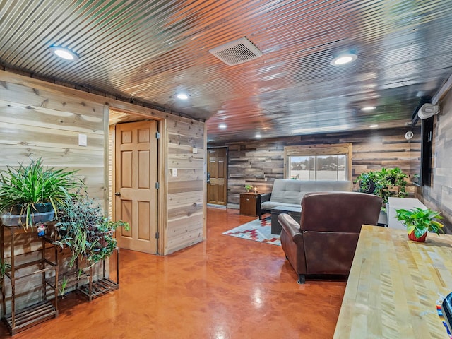 living room featuring wood walls, wooden ceiling, and concrete floors