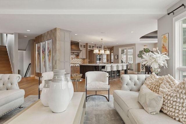 living room with light wood-type flooring and an inviting chandelier