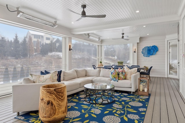 sunroom with ceiling fan and beamed ceiling