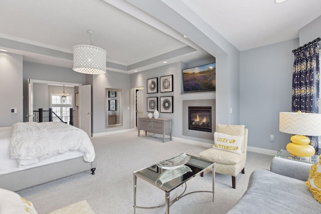 carpeted bedroom with a chandelier, a tray ceiling, and ornamental molding