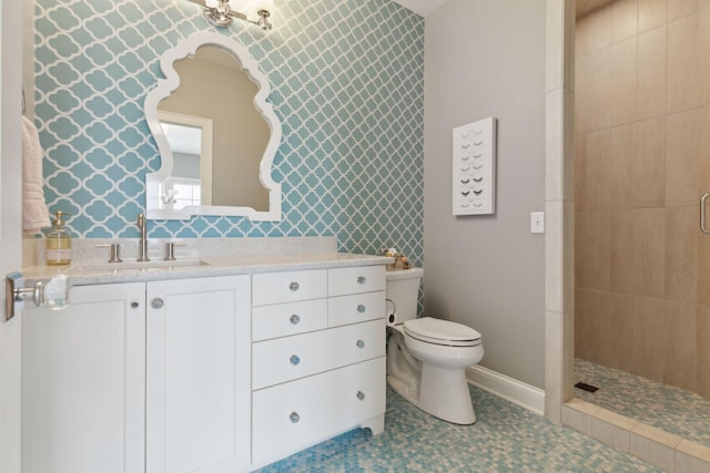 bathroom with vanity, toilet, and a tile shower